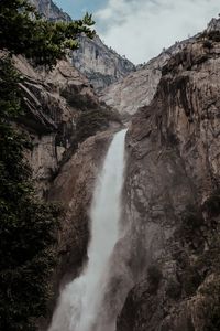 Scenic view of waterfall against sky