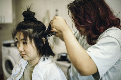 Teens dye their hair white, apply the dye to her hair at home