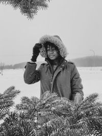 Man standing on snow field against sky during winter