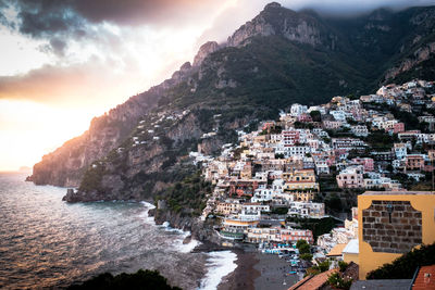 Aerial view of townscape by sea against sky