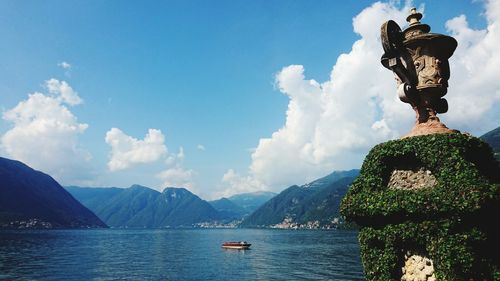 Statue by sea against sky