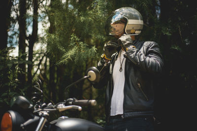 Man riding motorcycle against trees