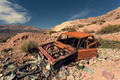 Old abandoned truck on mountain against sky