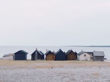 Huts at beach against clear sky