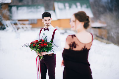 Man and woman standing by flowering plant