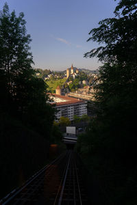 Train passing through city against sky