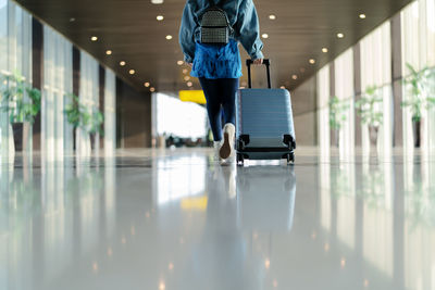 Rear view of man walking in airport building