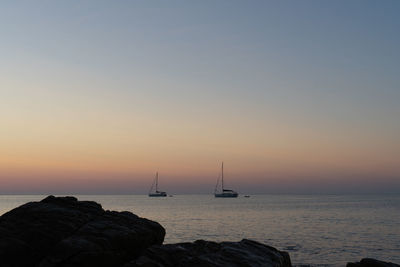 Sailboat on sea against sky during sunset