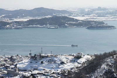Aerial view of city by sea during winter