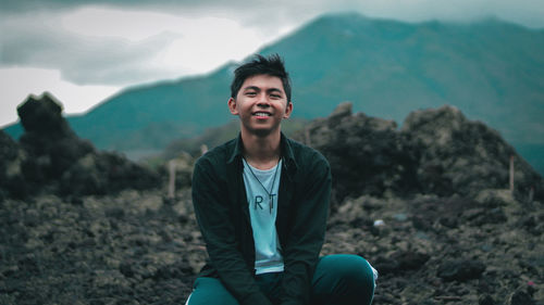 Portrait of young man standing on rock