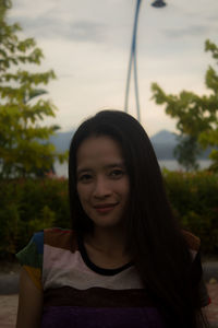 Portrait of smiling young woman at park