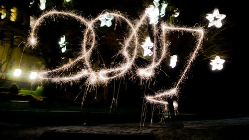 Illuminated firework display at night