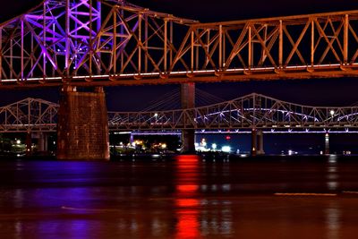 Low angle view of bridge over river at night