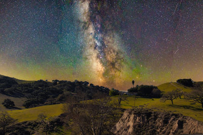 Scenic view of landscape against star field at night