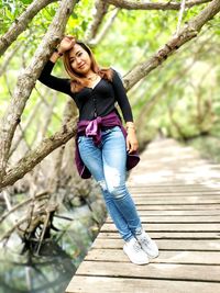 Portrait of smiling woman against tree trunk