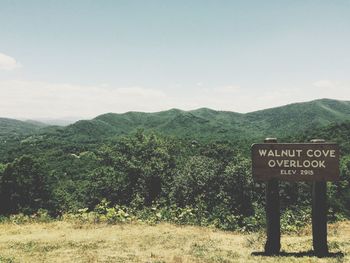 Information sign on mountain against sky