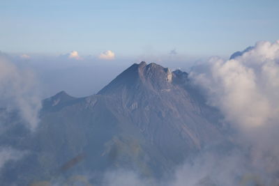 Scenic view of snowcapped mountains against cloudy sky