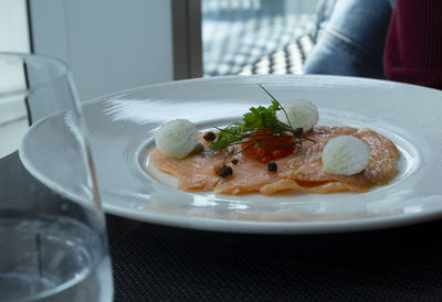 Smoke salmon on white plate in restaurant.