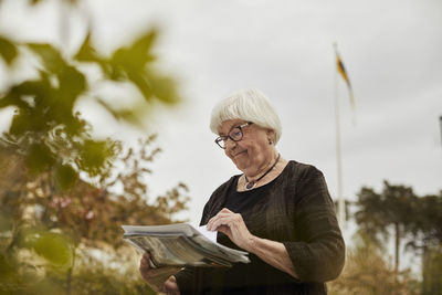 Senior woman holding newspaper