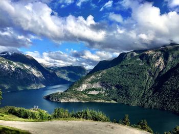 Scenic view of lake by mountains against sky