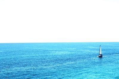 Sailboat sailing on sea against clear sky