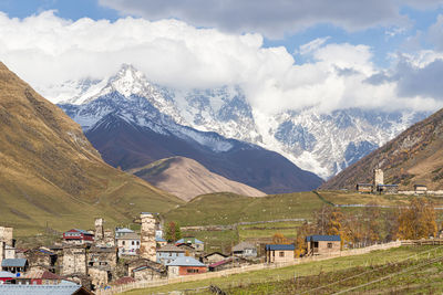 Scenic view of townscape and mountains against sky