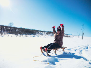 Person skiing on field during winter against sky