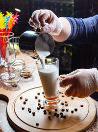 Midsection of man holding drink on table