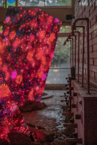 Close-up of pink hanging on alley amidst buildings