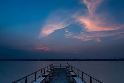 Pier over sea against sky during sunset