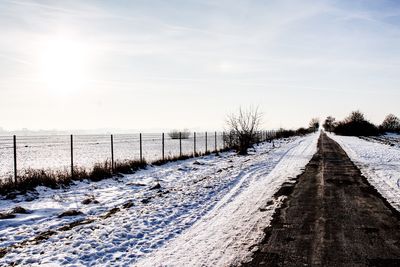 Snow covered landscape against sky