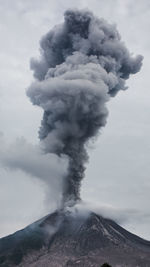 Smoke emitting from volcanic mountain against sky