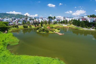 Scenic view of lake by buildings against sky