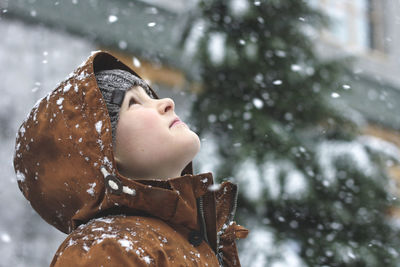 Boy looking up during snowy winter
