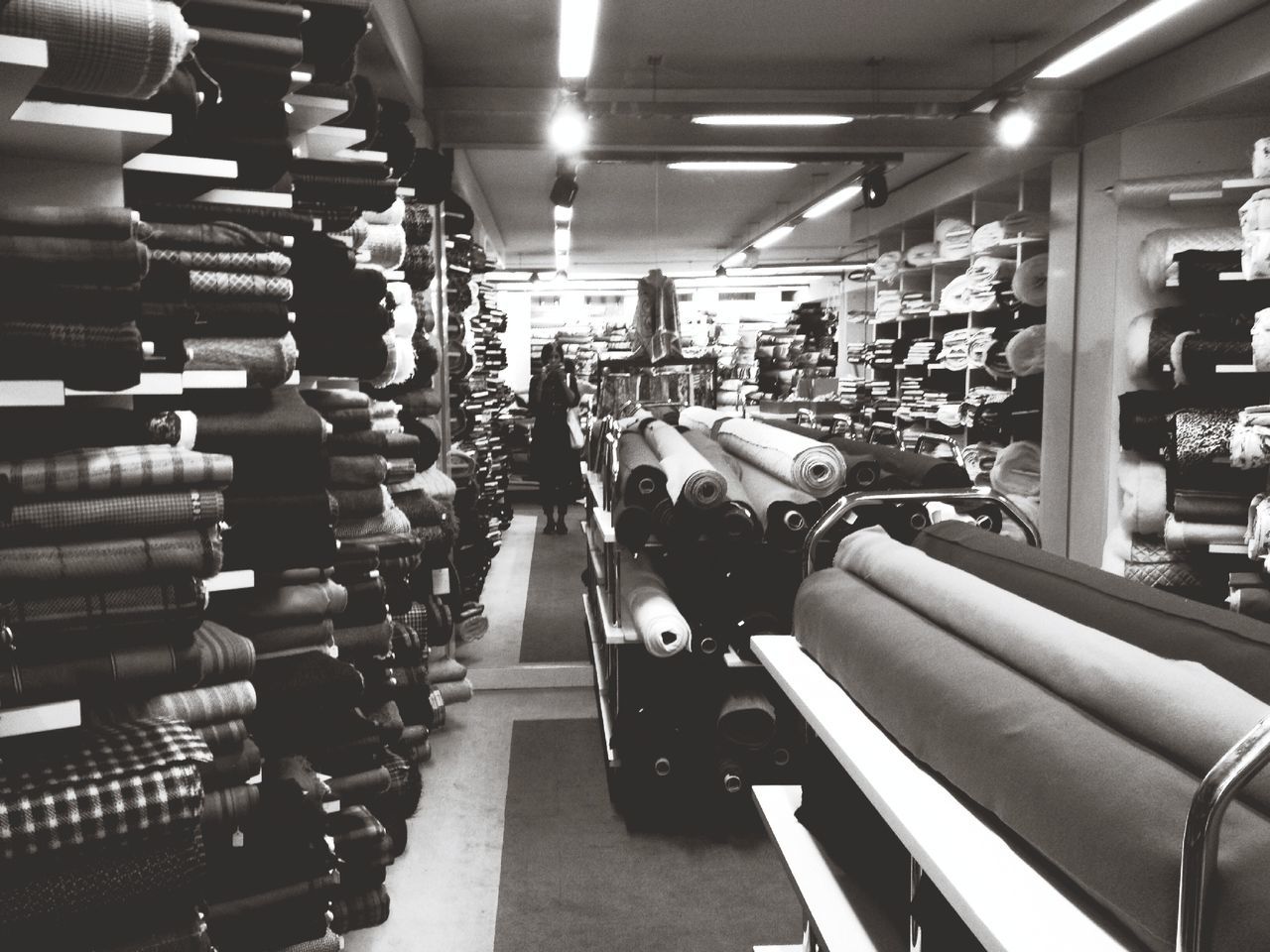 indoors, illuminated, in a row, large group of objects, lighting equipment, ceiling, arrangement, transportation, order, abundance, incidental people, retail, vehicle seat, choice, modern, night, variation, repetition, high angle view, chair