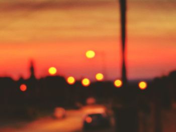 Close-up of illuminated lights against orange sky