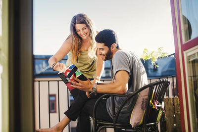 Couple reading guidebook together on balcony