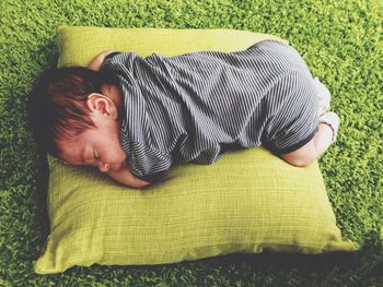High angle view of baby sleeping on cushion at home