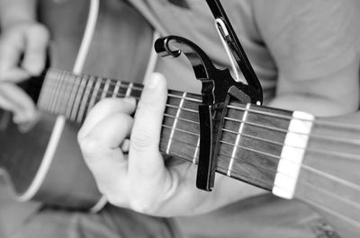 Midsection of man playing guitar