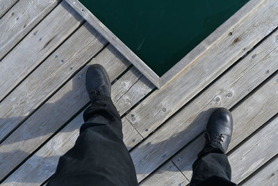 Low section of man on pier over lake
