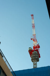 Low angle view of crane against clear blue sky