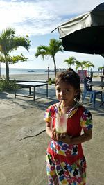 Portrait of girl having drink at beach