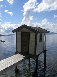 Built structure on pier by sea against sky