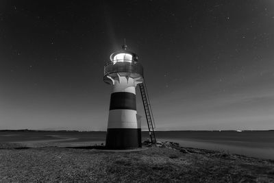 Low angle view of lighthouse against sky at night