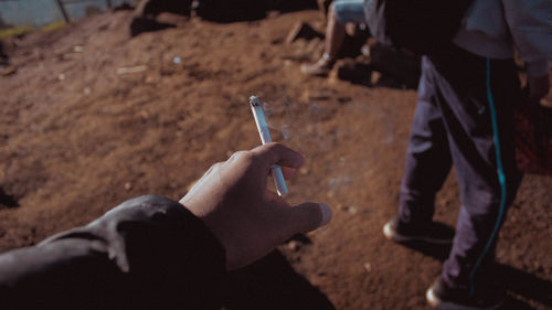 Cropped hand of man holding cigarette