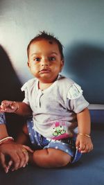 Portrait of cute baby girl sitting at home