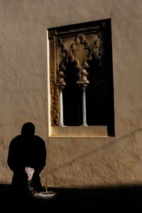 Man washing hands while standing against mosque