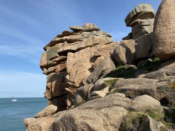 Low angle view of rocks on shore against sky