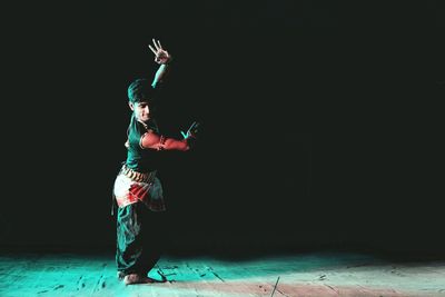 Full length of man wearing traditional clothing while dancing on stage