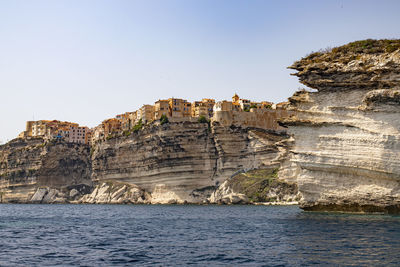 Rock formations by sea against clear sky corsica bonifacio